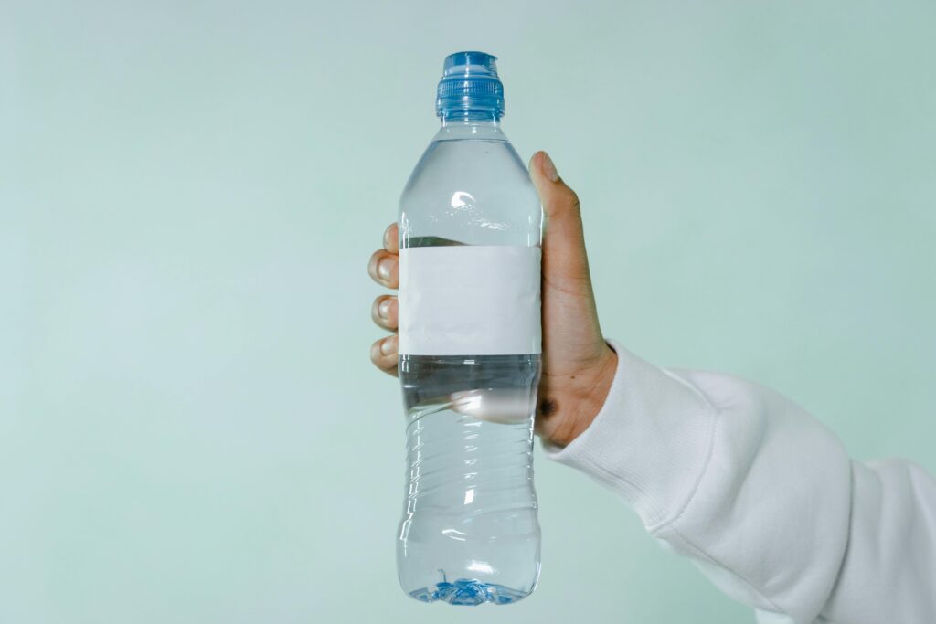 Person Holding Clear Plastic Bottle